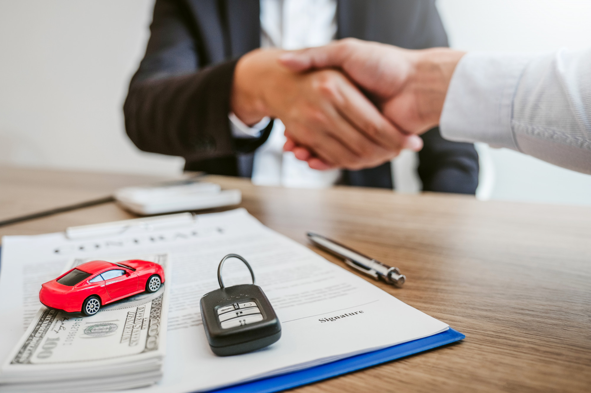 Car Deal - Sale agent handshake deal to agreement successful car loan contract with customer and sign agreement contract  Insurance car concept.